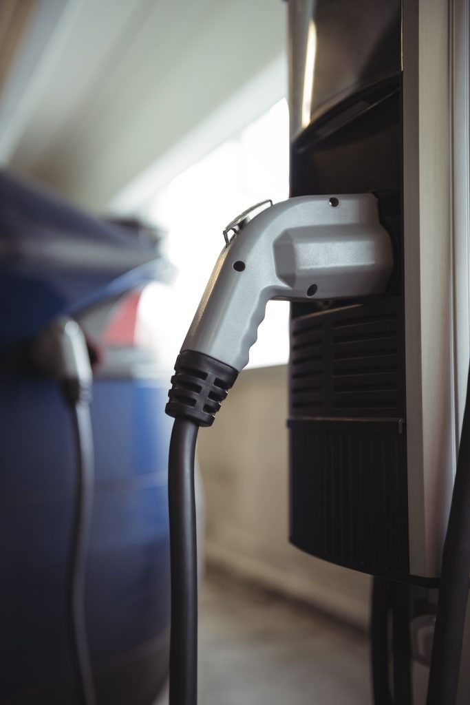 Close-up of car charger at electric vehicle charging station