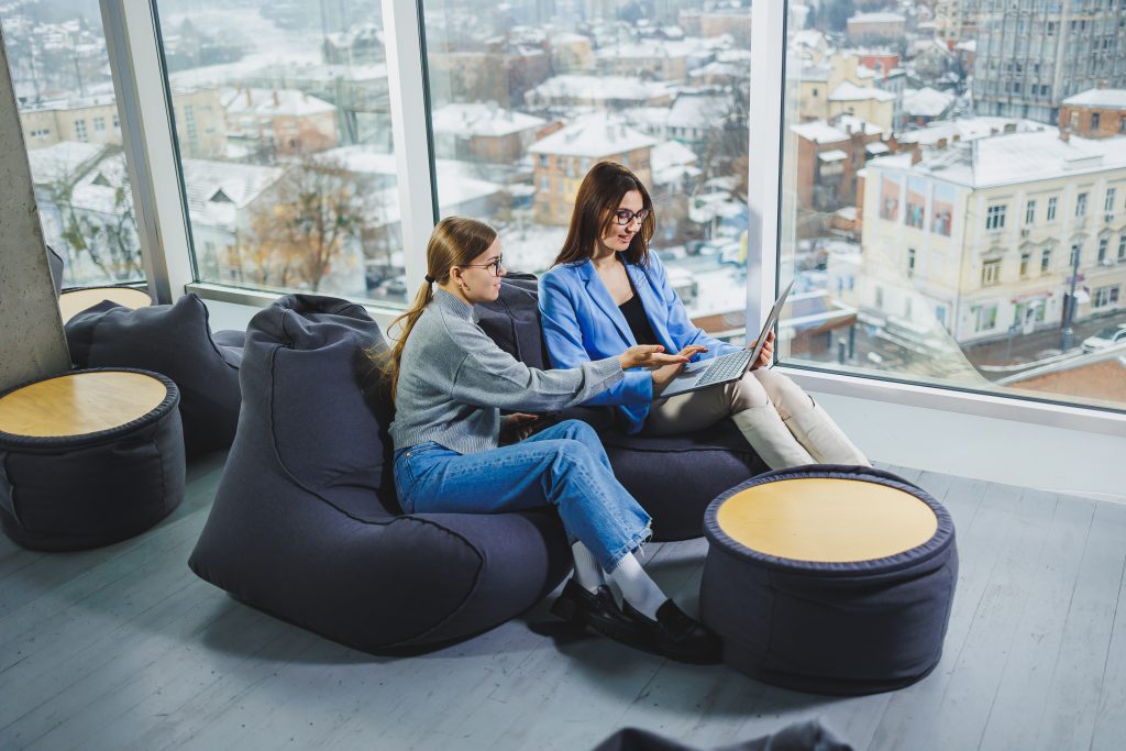 Business colleagues with digital gadgets meeting, browsing content on laptop and discussing project together while sitting during work break. Team work, corporate discussion Cobertura WiFi de alta calidad en habitaciones y zonas comunes de hotel