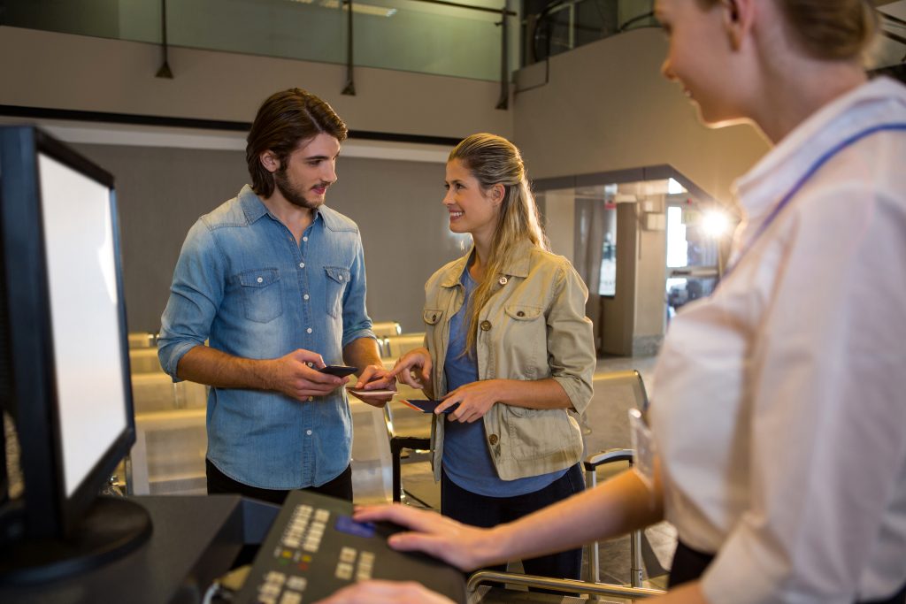 Couple interacting with each other at the check in counter in airport terminal
