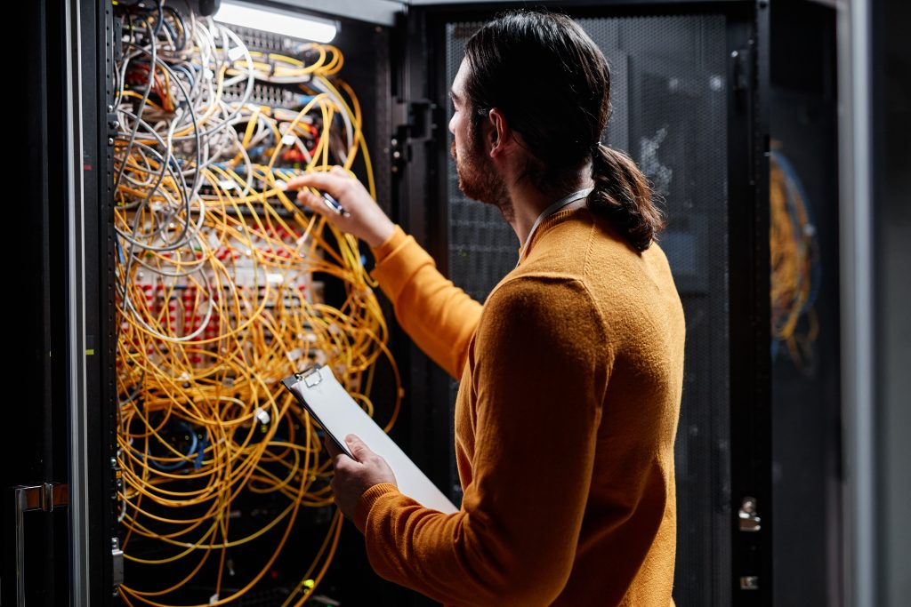 Network technician working with servers and connecting cables Instalación profesional de red WiFi en hoteles por Indafibra